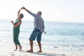 senior couple dancing on beach